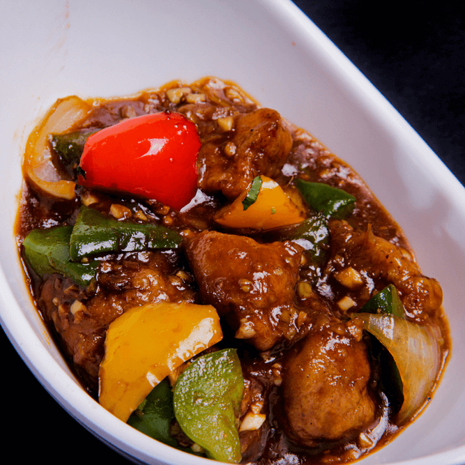 Spicy Indo-Chinese chilli chicken with spring onions and sauce
