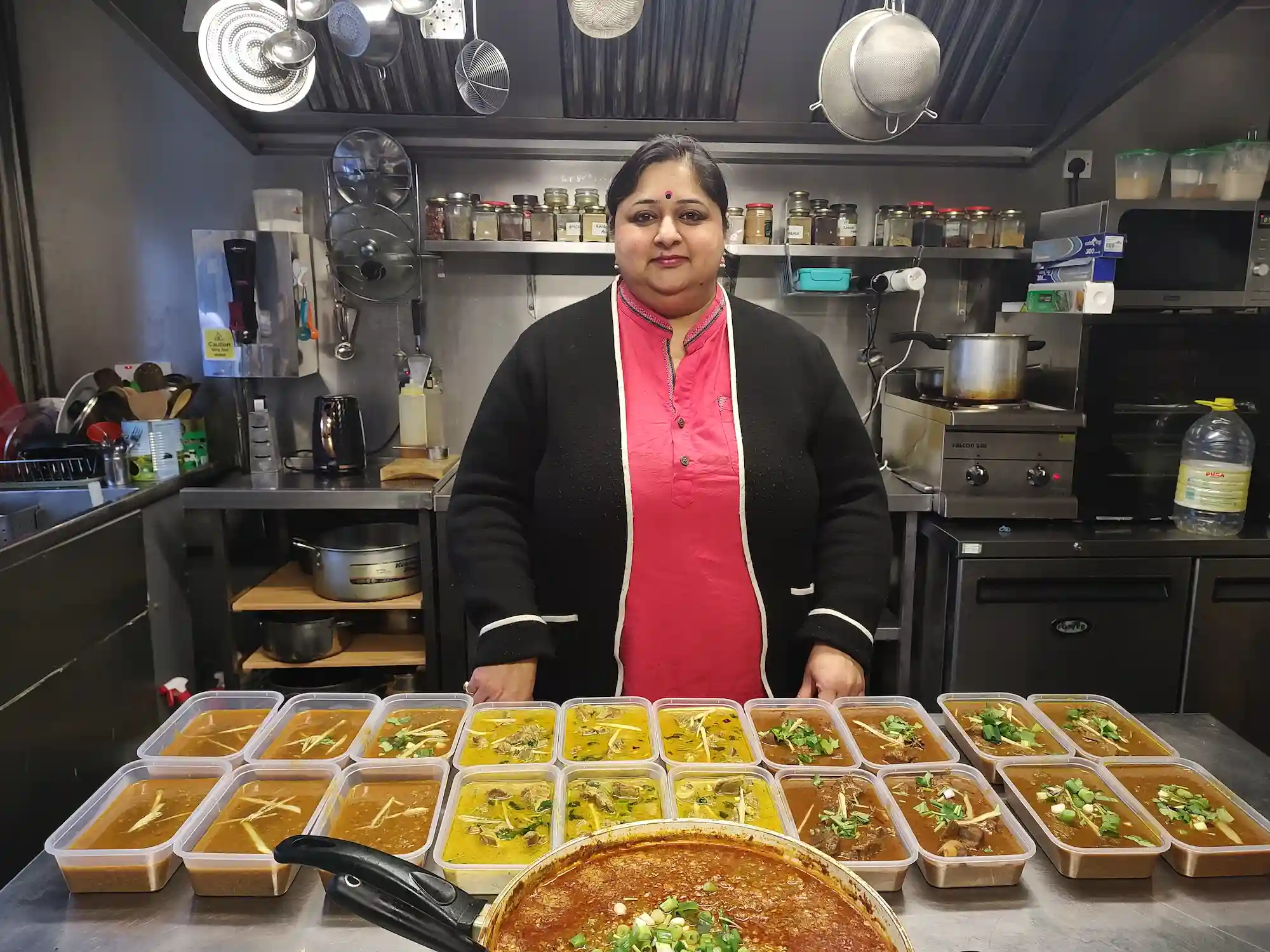 A Kitchen Queen with trays of freshly prepared dishes